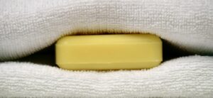Saponetta posizionata sotto le lenzuola su un letto, simbolo di un trucco per migliorare il sonno.
