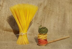 Riso e pasta su un tavolo, con un piatto e posate, per illustrare la scelta alimentare serale.