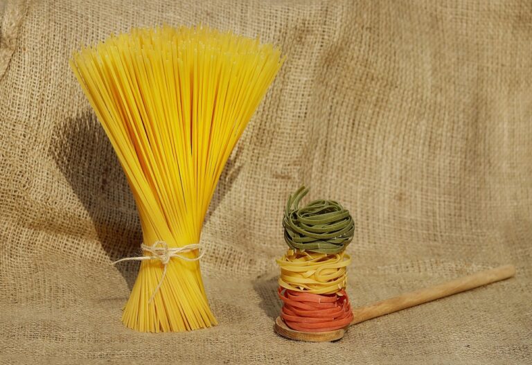 Riso e pasta su un tavolo, con un piatto e posate, per illustrare la scelta alimentare serale.